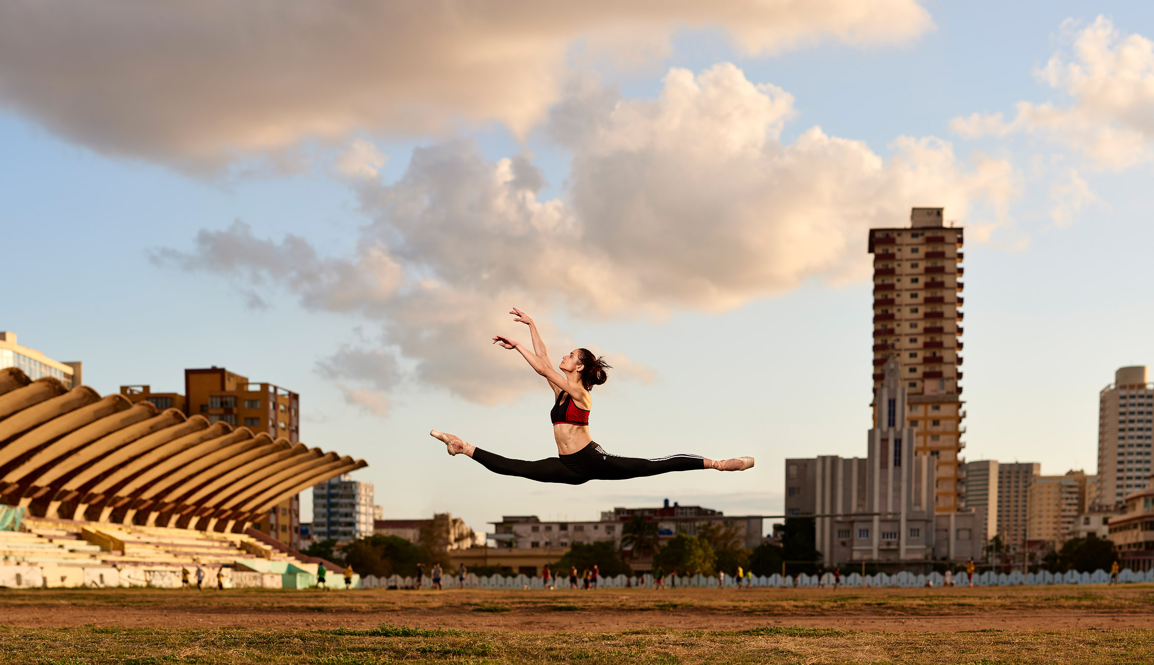 Gabriella jumping with Jose Marti Stadium, Cuba in background.