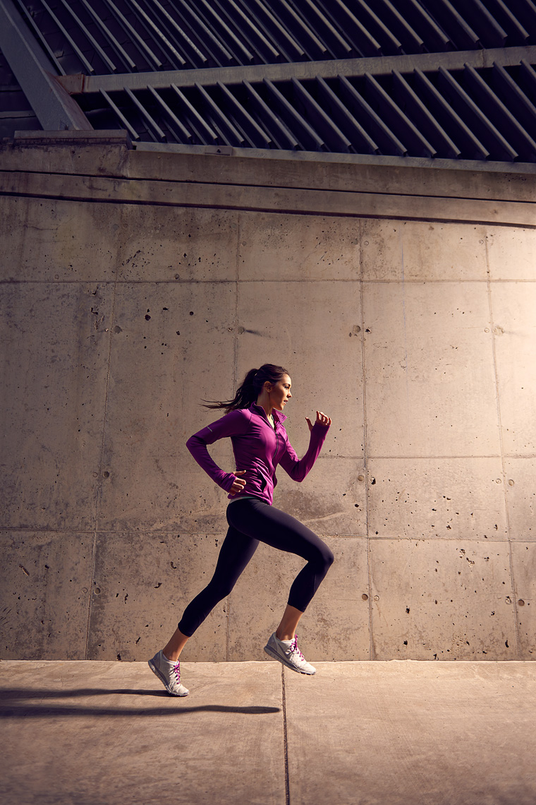 Woman running in city wearing pink.